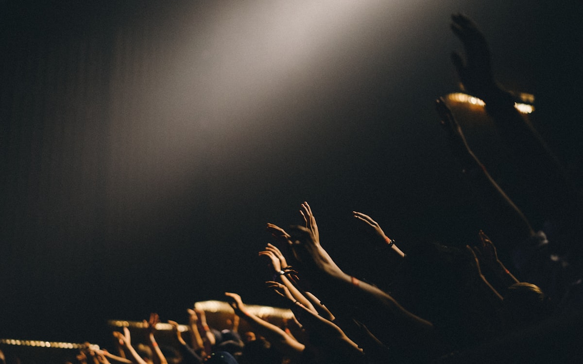 Hands raised in warm stage light during a worship set